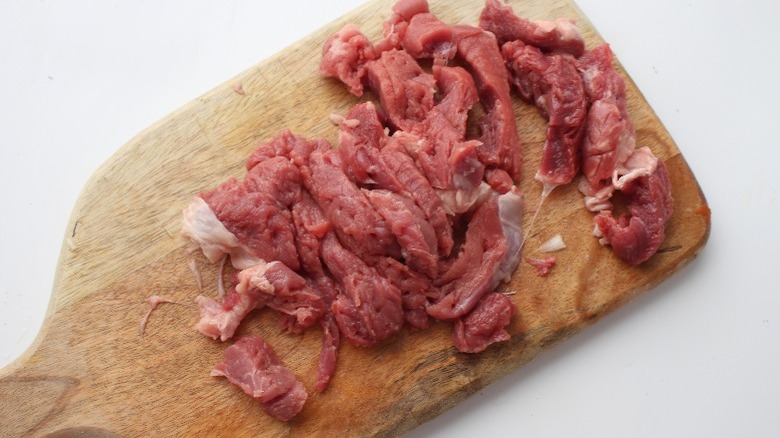 sliced raw steak on cutting board