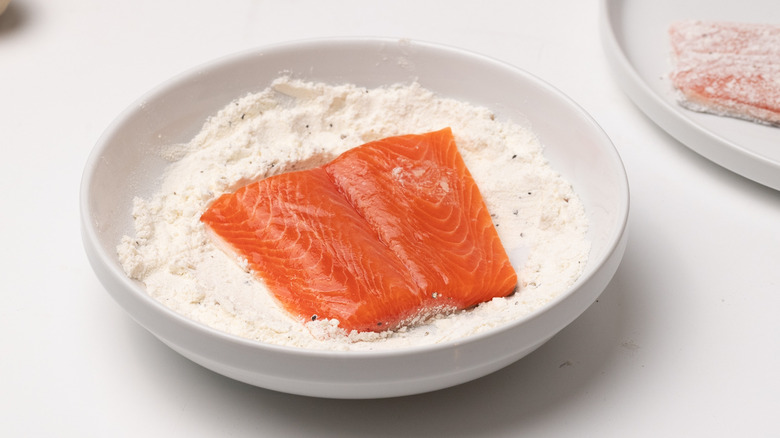 coating trout in seasoned flour