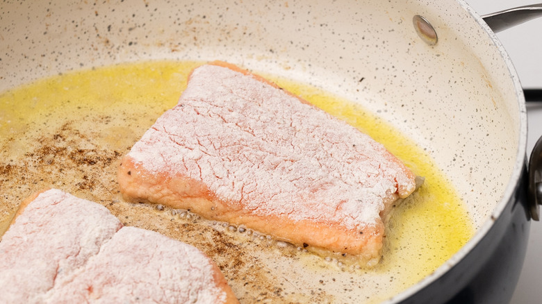 trout frying in a pan