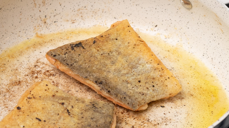 trout frying in a pan