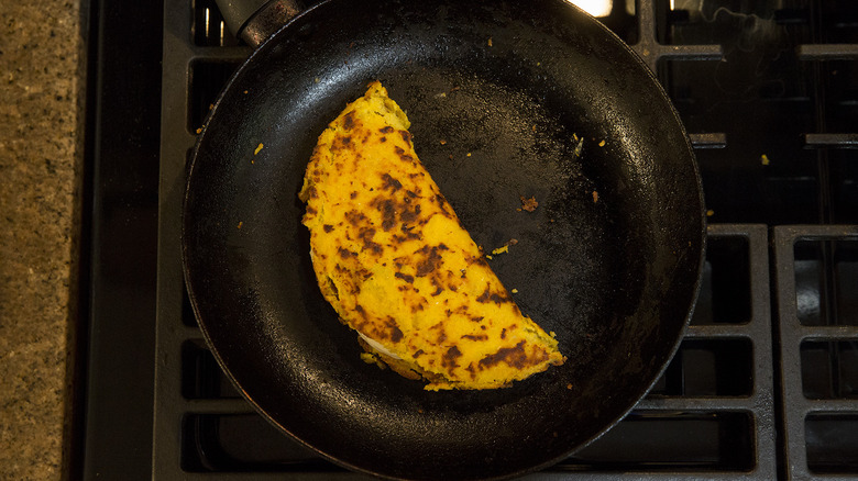 folded cachapa in frying pan