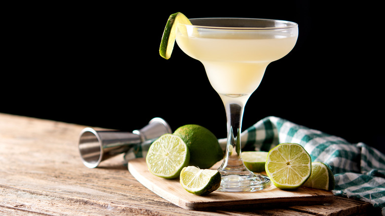 Daiquiri and limes on cutting board 