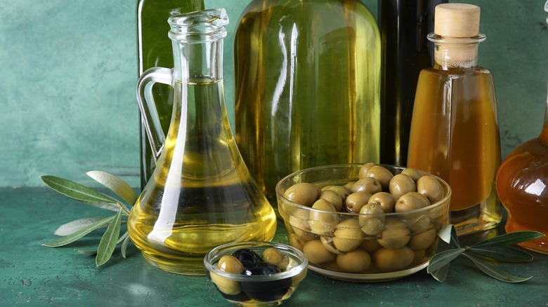 A variety of olive oil jars with olives