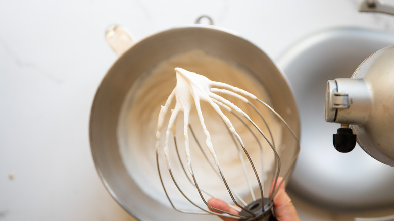 Whipped coffee cream on whisk