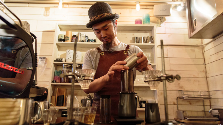 Man using an AeroPress coffee brewer