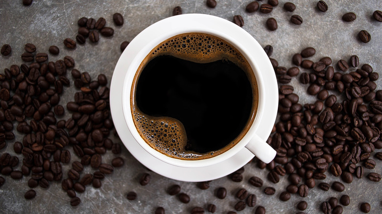 A coffee cup surrounded by coffee beans