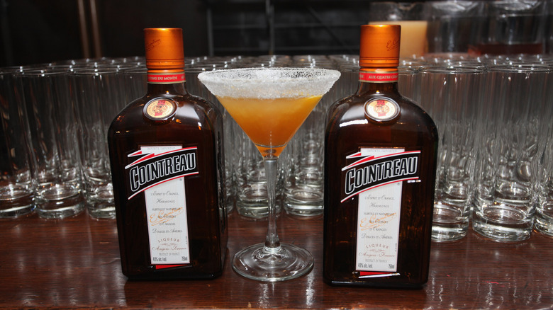 cointreau bottles with cocktail on bar