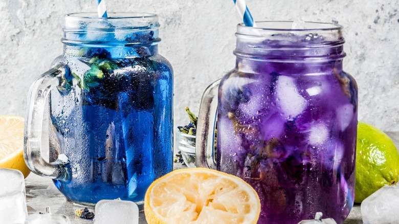 Blue and purple butterfly pea color-changing drinks in glass jars