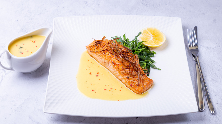 Salmon and beurre blanc on white plate