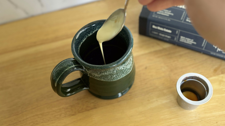 pouring creamer into coffee