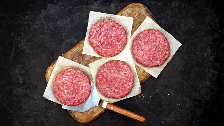 Hamburger patties on cutting board