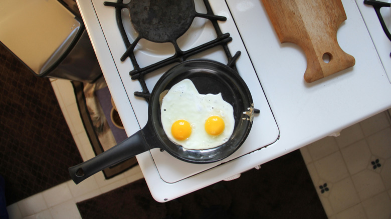 Cast Iron pan on gas stovetop with sunny side up eggs