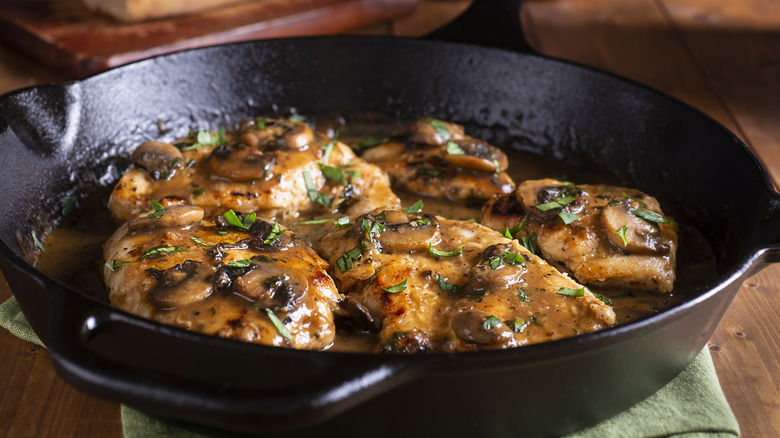 chicken thighs with mushroom gravy in a cast iron skillet