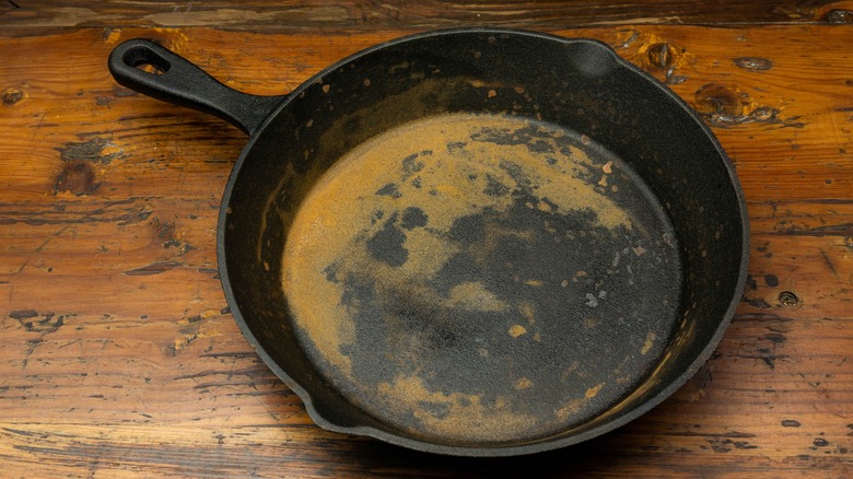 rusty cast iron skillet on wooden table