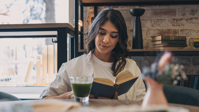 Woman reading a book in a café