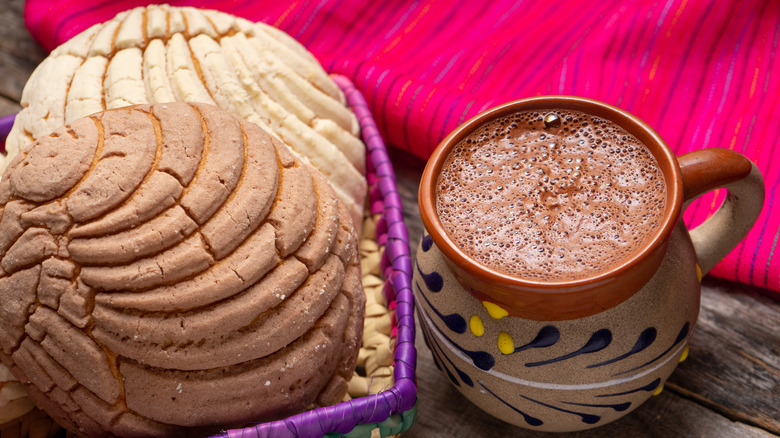 Conchas next to a mug of hot chocolate 