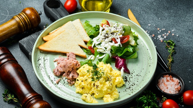 Scrambled eggs, tuna, toast, and salad