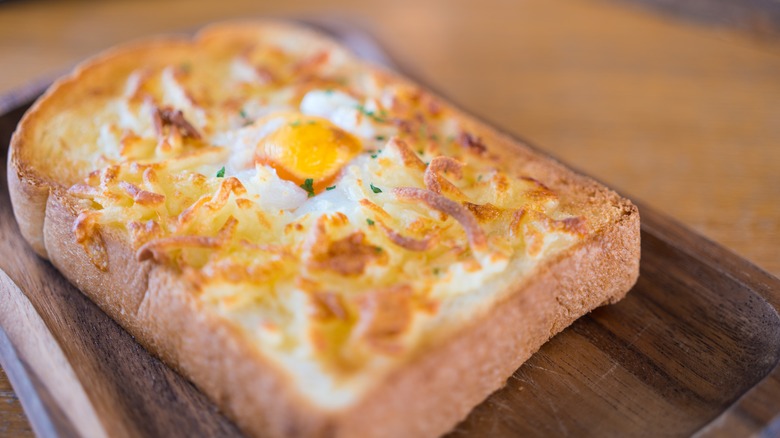 egg in a hole cheese toaston a wood board