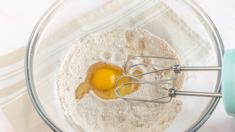 mixing egg into cupcake batter 