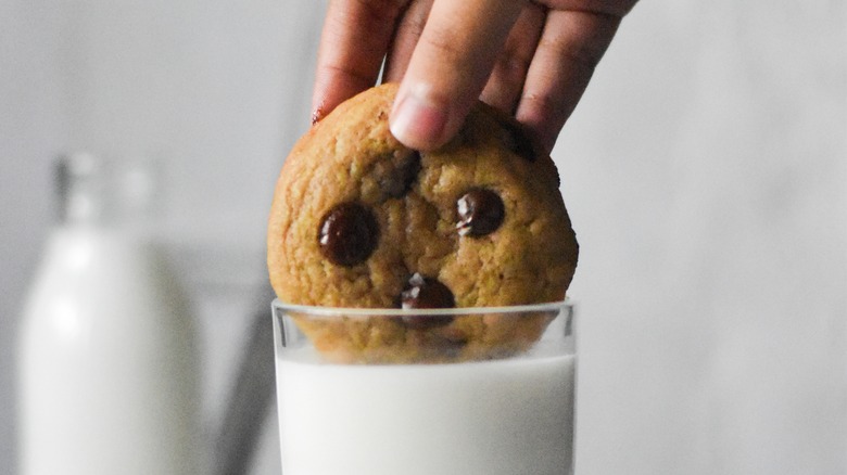 Foodie dunking a cookie into a glass of milk