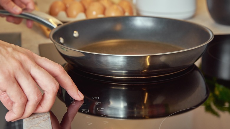 A woman heating a pan