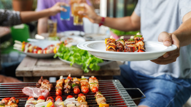 skewers of meat and vegetables being grilled and on a plate