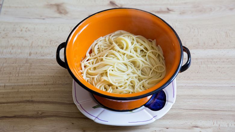 pasta sitting in orange colander