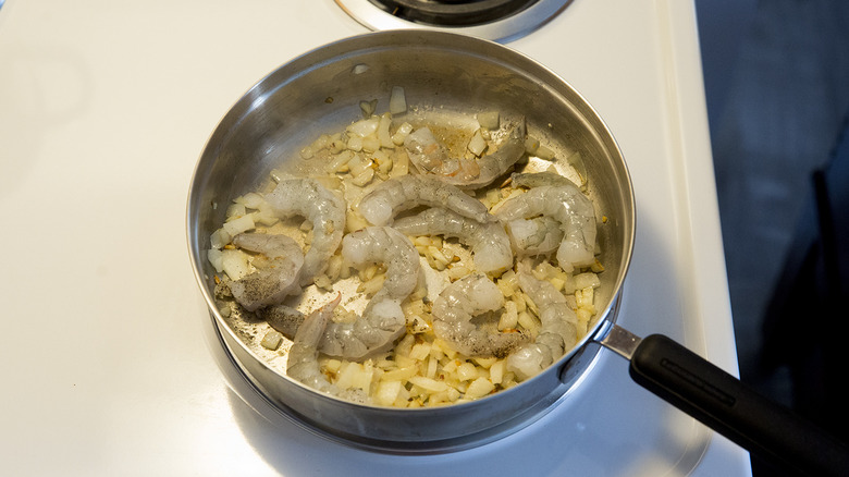 raw shrimp cooking in pan