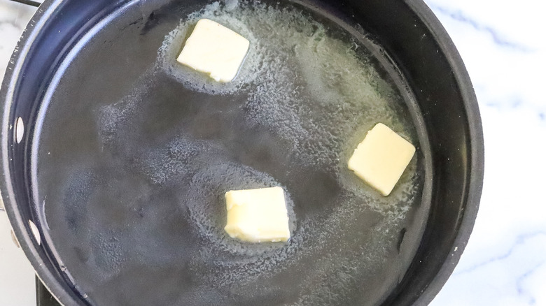 chunks of butter melting in a frying pan