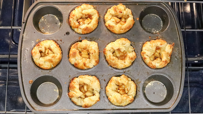 apple-filled pastries in a muffin pan