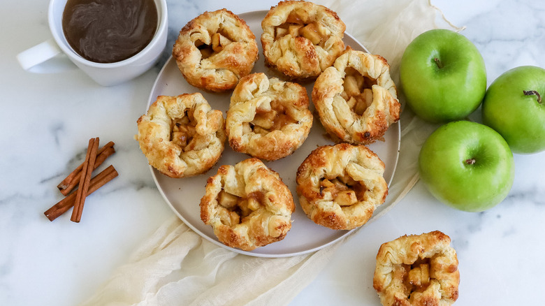 apple-filled pastries with cinnamon sticks, apples, and coffee