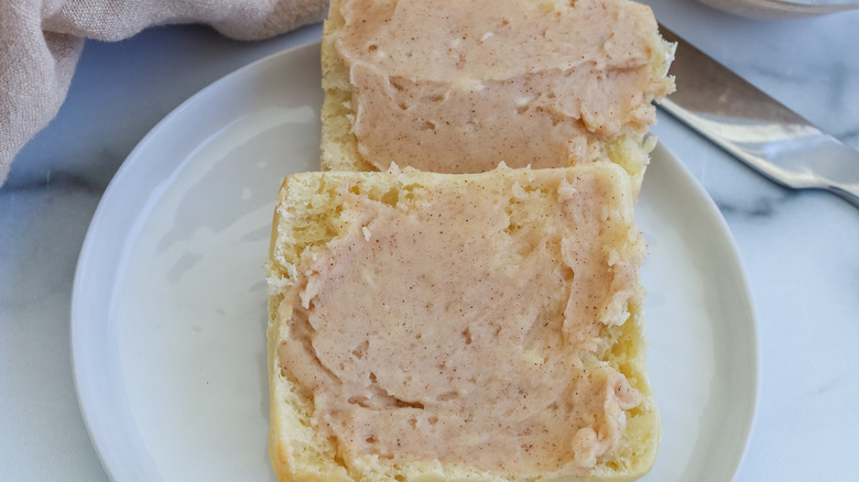 A close-up of a roll spread with cinnamon butter