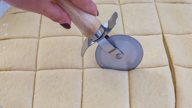 Roll dough being cut with a pizza cutter