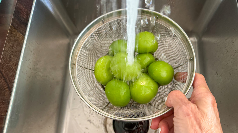 hand holding colander under water