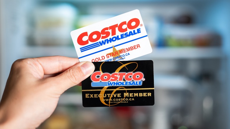 Hand holding Costco membership cards