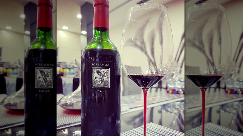 A bottle of Screaming Eagle red wine next to a filled glass