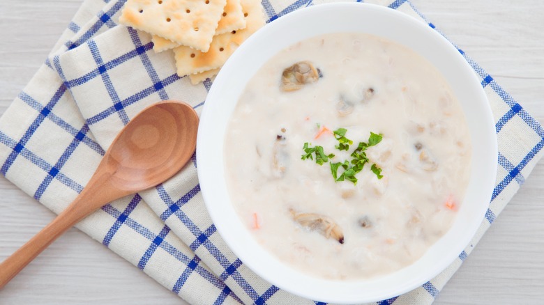 Clam chowder with crackers and wooden spoon