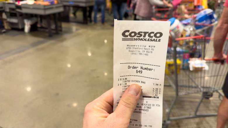 Someone holding a Costco receipt in the store