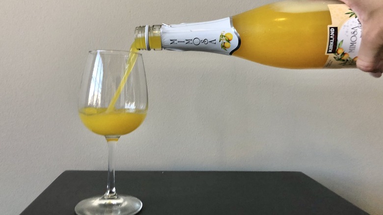 Pouring Kirkland mimosa into glass