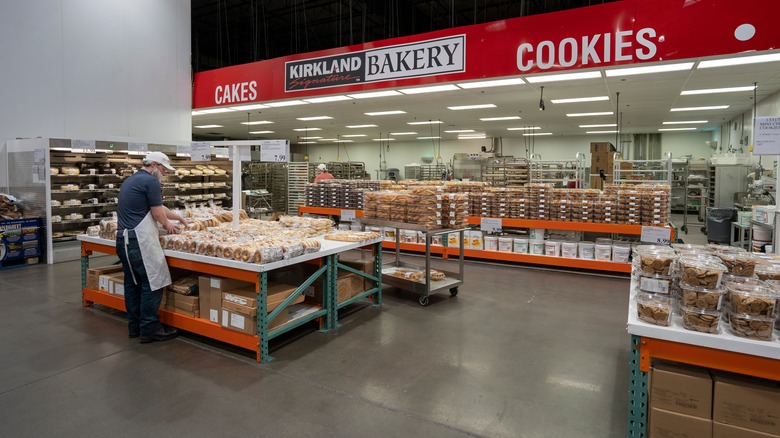 Worker stocking Costco bakery items