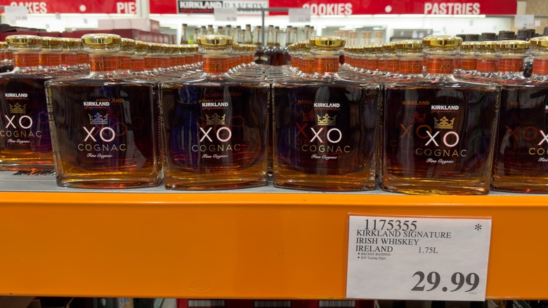 Costco price tag with an asterisk for bottles of cognac