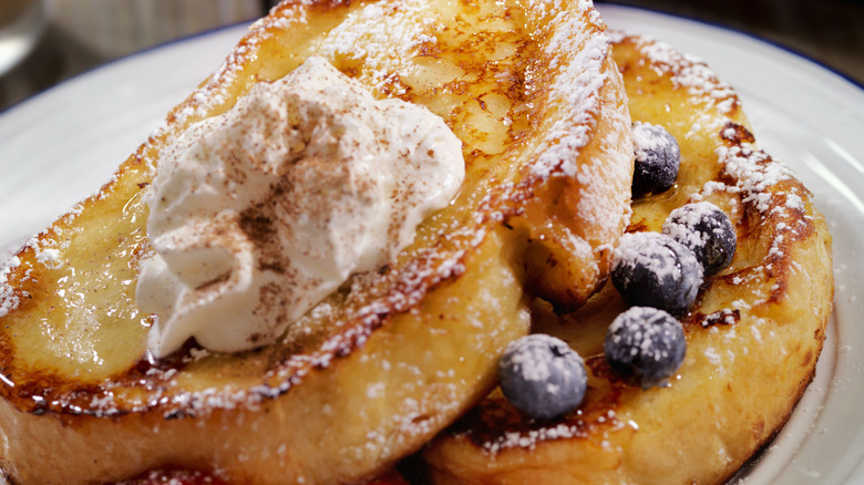 Close-up of French toast with creamy topping and blueberries 