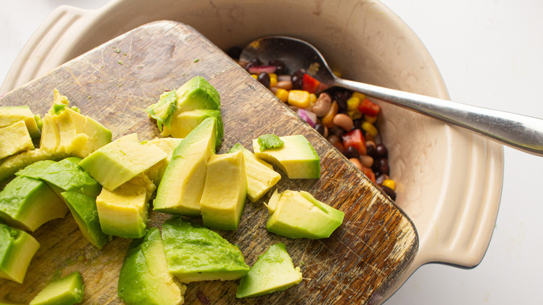 adding avocado to bowl