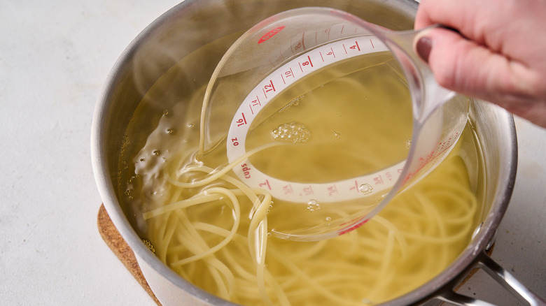 reserving pasta water from pot