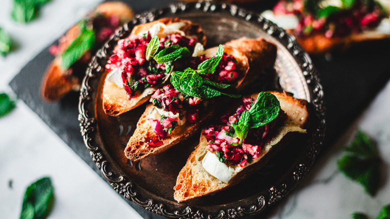 Crostini slices on metal tray atop black cutting board