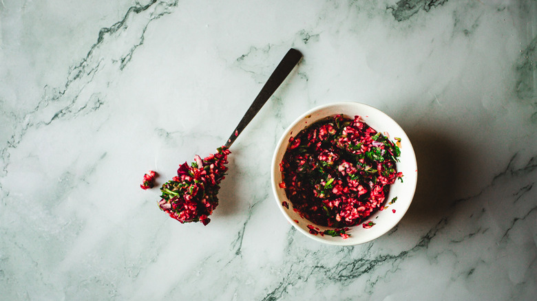 Salsa with spoon beside bowl