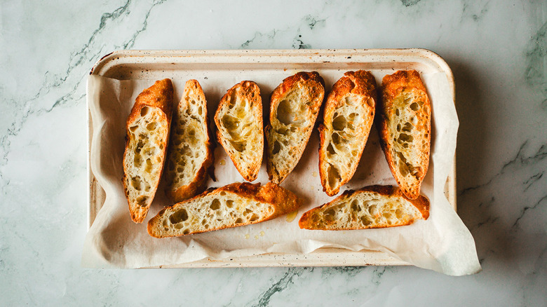 Toasted baguette slices on baking sheet