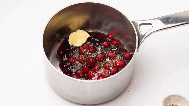 saucepan containing cranberries and rosemary