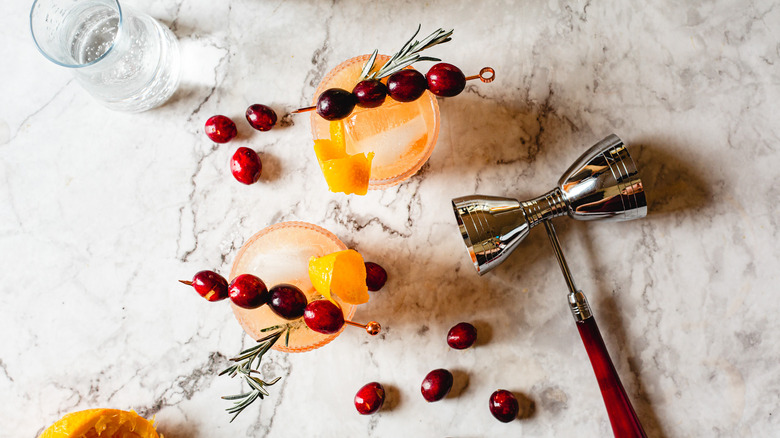 two cocktail glasses with jigger and soda 