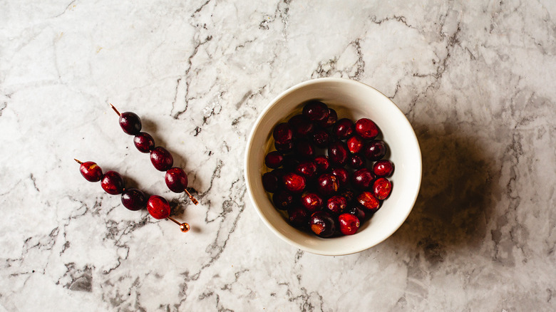 cranberries on cocktail picks beside bowl